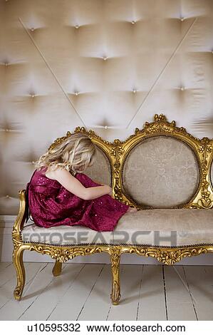 Stock Image - Young girl in a party dress crying or sulking. Fotosearch