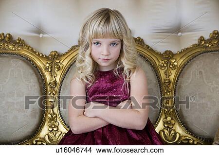 Picture - Young girl in a party dress looking bored and unhappy. Fotosearch