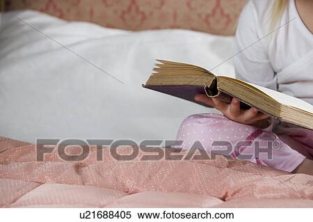 Young girl in her bedroom reading a book View Large Photo Image Stock Photography - Young girl in her bedroom reading a book . Fotosearch