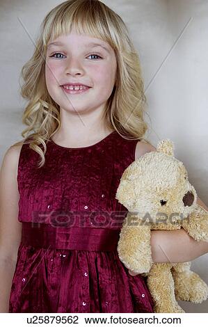 Young girl in party dress, holding a teddy bear View Large Photo Image Stock Image - Young girl in party dress, holding a teddy bear. Fotosearch