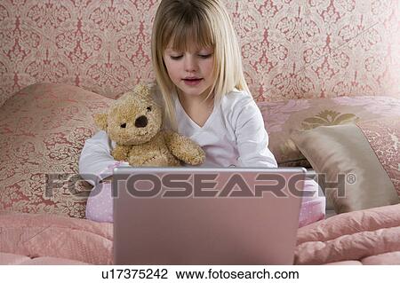 Young girl using a laptop computer in her bedroom View Large Photo Image Stock Image - Young girl using a laptop computer in her bedroom . Fotosearch