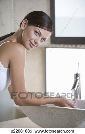A woman washing at a sink View Large Photo Image Stock Photography - A woman washing at a sink. Fotosearch