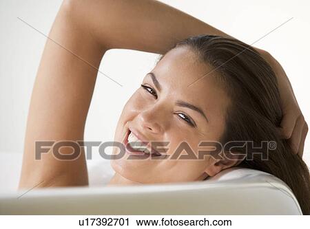 Stock Image - A young woman in the bath, close-up. Fotosearch