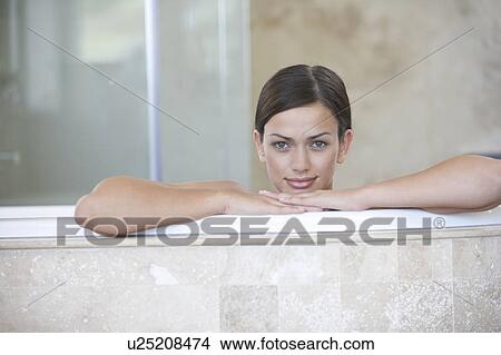 A young woman sitting in a bath View Large Photo Image Picture - A young woman sitting in a bath. Fotosearch