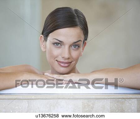 Stock Photo - A young woman sitting in a bath. Fotosearch