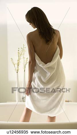Stock Photography - A young woman standing in a bath. Fotosearch