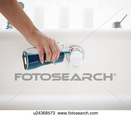 Pouring bath oil in a bath View Large Photo Image Stock Image - Pouring bath oil in a bath. Fotosearch