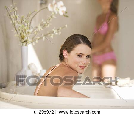 Stock Image - Two young women in a bathroom. Fotosearch