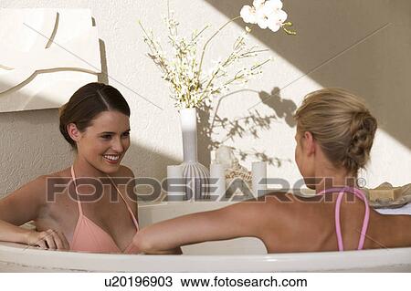 Stock Image - Two young women in a bathroom. Fotosearch