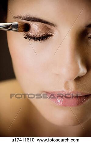 Stock Image - Woman applying eyeshadow. Fotosearch