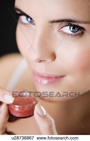 Woman applying lip gloss View Large Photo Image Stock Photo - Woman applying lip gloss. Fotosearch