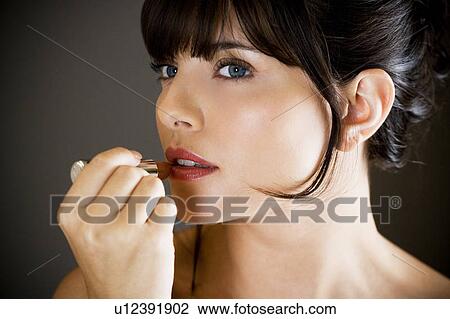 Woman applying lipstick View Large Photo Image Stock Image - Woman applying lipstick. Fotosearch
