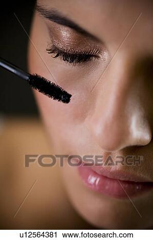 Stock Image - Woman applying mascara. Fotosearch