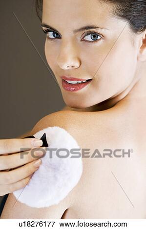 Woman putting powder on her skin with a powder puff View Large Photo Image Stock Photo - Woman putting powder on her skin with a powder puff. Fotosearch