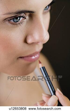 Woman using a lip pencil View Large Photo Image Stock Photo - Woman using a lip pencil. Fotosearch