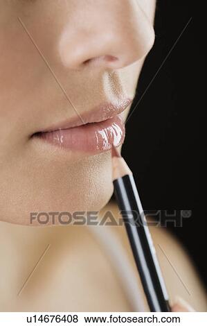 Stock Photo - Woman using a lip pencil. Fotosearch