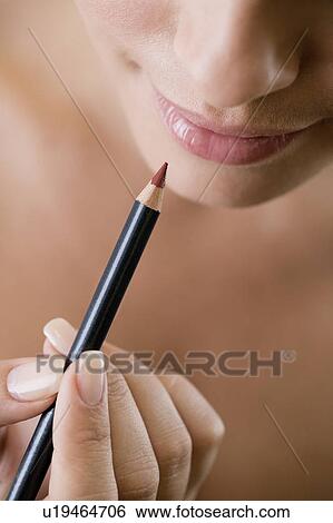 Woman using a lip pencil View Large Photo Image Stock Photograph - Woman using a lip pencil. Fotosearch