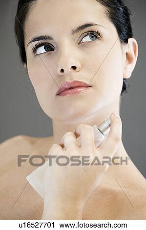 Young woman spraying perfume on her neck View Large Photo Image Stock Image - Young woman spraying perfume on her neck. Fotosearch