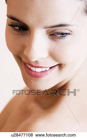 Stock Photo - Portrait of young woman, looking downwards. Fotosearch