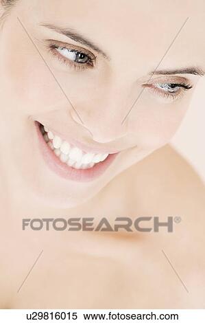 Portrait of young woman smiling, looking away from camera View Large Photo Image Stock Photography - Portrait of young woman smiling, looking away from camera. Fotosearch