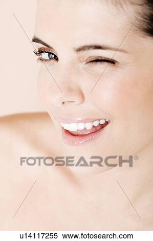 Stock Photography - Portrait of young woman winking to camera. Fotosearch