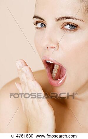 Stock Image - Portrait of young woman yawning. Fotosearch