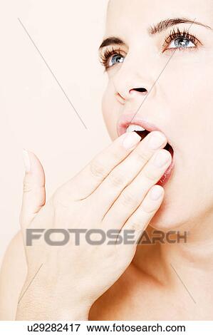 Stock Photo - Portrait of young woman yawning. Fotosearch