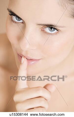 Woman putting her finger to her lips View Large Photo Image Picture - Woman putting her finger to her lips. Fotosearch