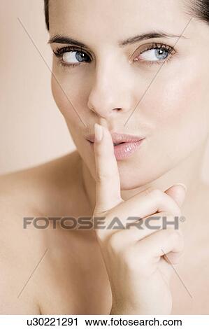 Stock Image - Woman putting her finger to her lips. Fotosearch