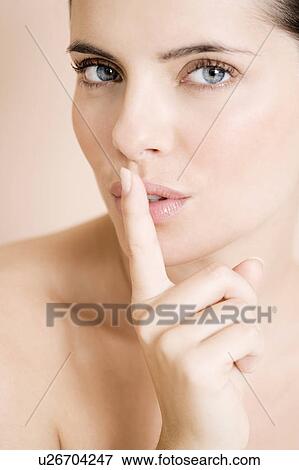 Woman putting her finger to her lips View Large Photo Image Stock Photo - Woman putting her finger to her lips. Fotosearch