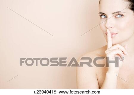 Stock Photography - Woman putting her finger to her lips. Fotosearch