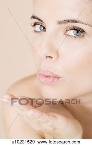 Stock Photo - Young woman blowing a kiss. Fotosearch