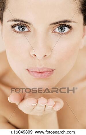 Stock Photo - Young woman blowing a kiss to camera. Fotosearch