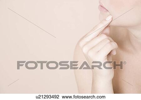Detail of young woman holding a finger to her chin, thinking View Large Photo Image Stock Image - Detail of young woman holding a finger to her chin, thinking. Fotosearch