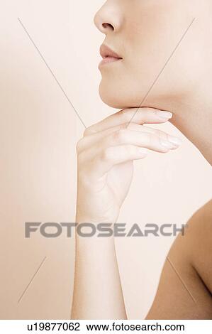 Detail of young woman's face, hand held under her chin View Large Photo Image Stock Image - Detail of young woman's face, hand held under her chin. Fotosearch