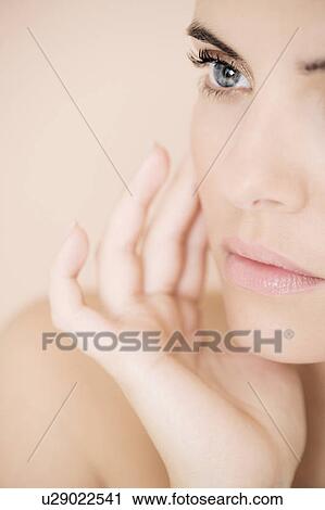 Portrait of young woman holding her hand to her face View Large Photo Image Stock Image - Portrait of young woman holding her hand to her face. Fotosearch