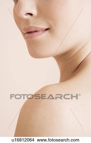 Young woman looking over her shoulder, cropped view View Large Photo Image Picture - Young woman looking over her shoulder, cropped view . Fotosearch