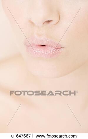 Stock Image - Young woman pouting, close-up of mouth. Fotosearch