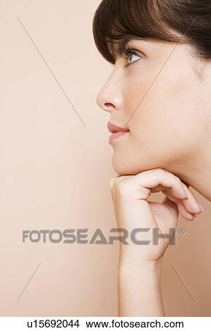 Cropped portrait of a young woman with her chin on her hand View Large Photo Image Picture - Cropped portrait of a young woman with her chin on her hand. Fotosearch