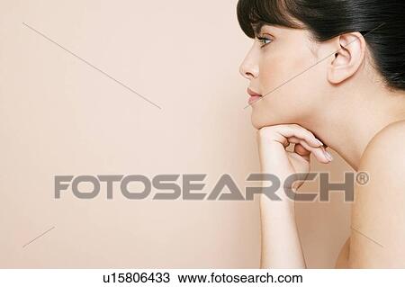 Stock Image - Cropped portrait of a young woman with her chin on her hand. Fotosearch