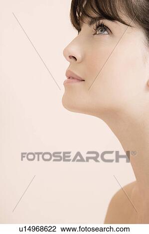 Cropped portrait of young woman looking upwards View Large Photo Image Stock Image - Cropped portrait of young woman looking upwards. Fotosearch