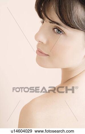 Portrait of young woman looking over her shoulder View Large Photo Image Stock Photo - Portrait of young woman looking over her shoulder. Fotosearch