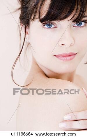 Picture - Portrait of young woman with brown hair looking over her shoulder. Fotosearch