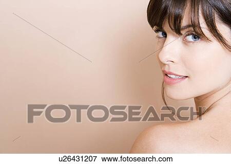 Portrait of young woman with brown hair looking over her shoulder, profile View Large Photo Image Stock Photo - Portrait of young woman with brown hair looking over her shoulder, profile. Fotosearch