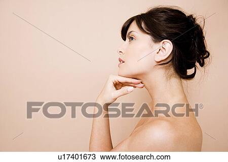 Side view of young woman with dark hair in a bun View Large Photo Image Stock Image - Side view of young woman with dark hair in a bun. Fotosearch