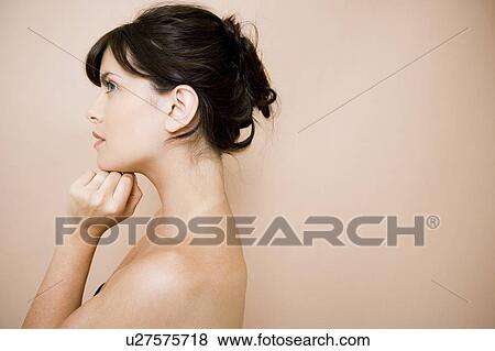 Side view of young woman with dark hair in a bun View Large Photo Image Stock Photo - Side view of young woman with dark hair in a bun. Fotosearch