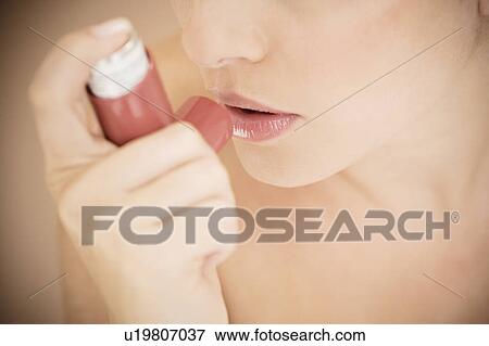 Female asthma sufferer using an inhaler View Large Photo Image Stock Photo - Female asthma sufferer using an inhaler. Fotosearch