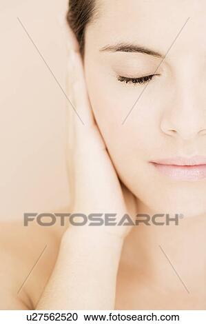 Portrait of young woman holding her hand beside her face, eye closed View Large Photo Image Stock Image - Portrait of young woman holding her hand beside her face, eye closed. Fotosearch