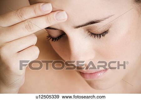 Portrait of young woman with eyes closed and fingers on her temple, headache View Large Photo Image Stock Photo - Portrait of young woman with eyes closed and fingers on her temple, headache. Fotosearch