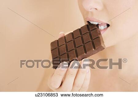 Woman eating a bar of chocolate View Large Photo Image Stock Image - Woman eating a bar of chocolate. Fotosearch